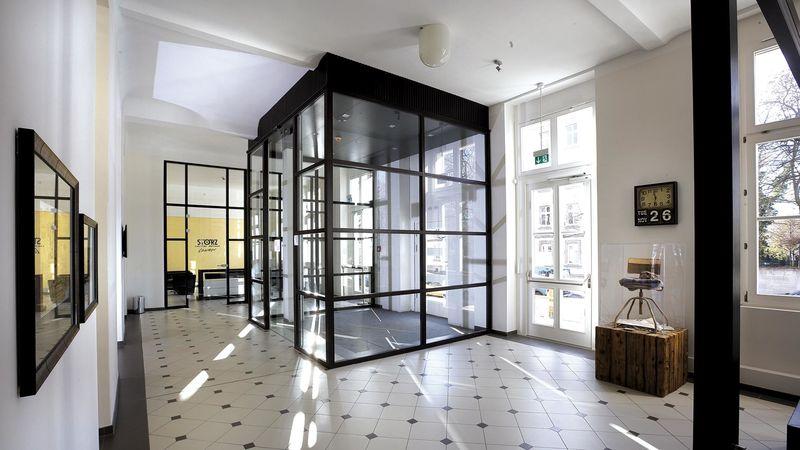 Eingangsbereich mit Glaswindfang und Retro-Fliesenboden schwarz-weiß