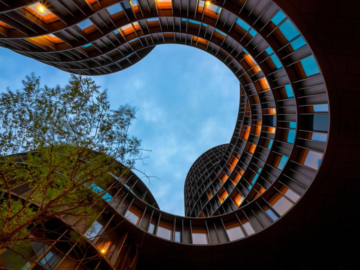 wellenförmiger Büroturm Blick aus dem Innenhof in den Himmel